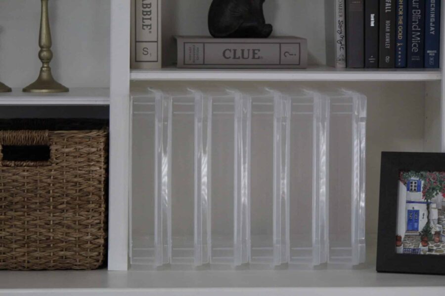 Scrapbook storage display cases stacked upright on a bookshelf