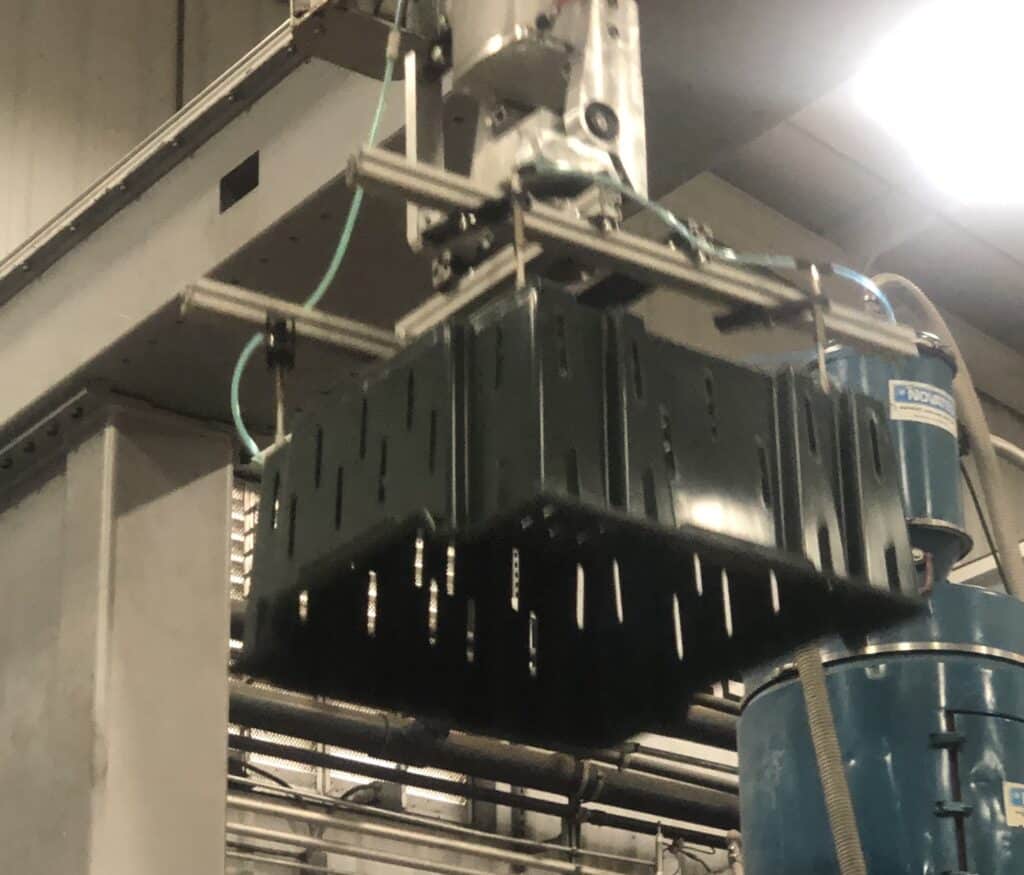 mass production custom injection molding part being held by a robot