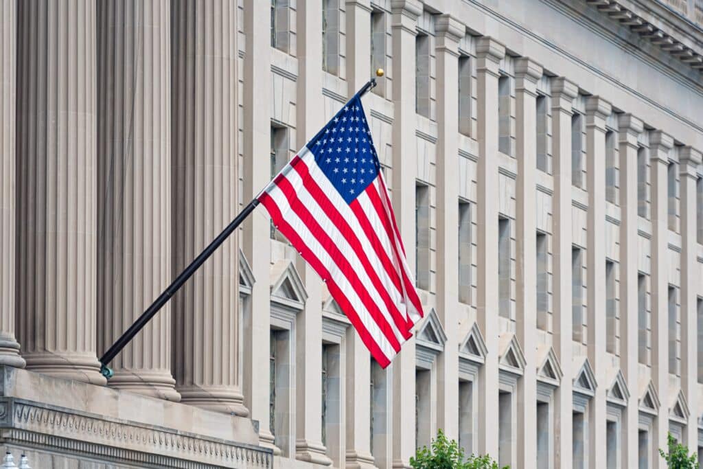 American flag proudly displayed on a historic buildings facade.