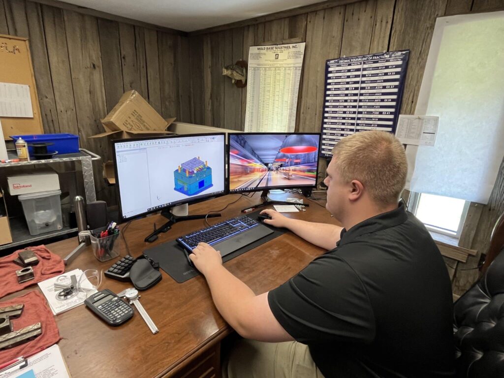 Engineer working on office design using dual monitors for efficient project visualization.