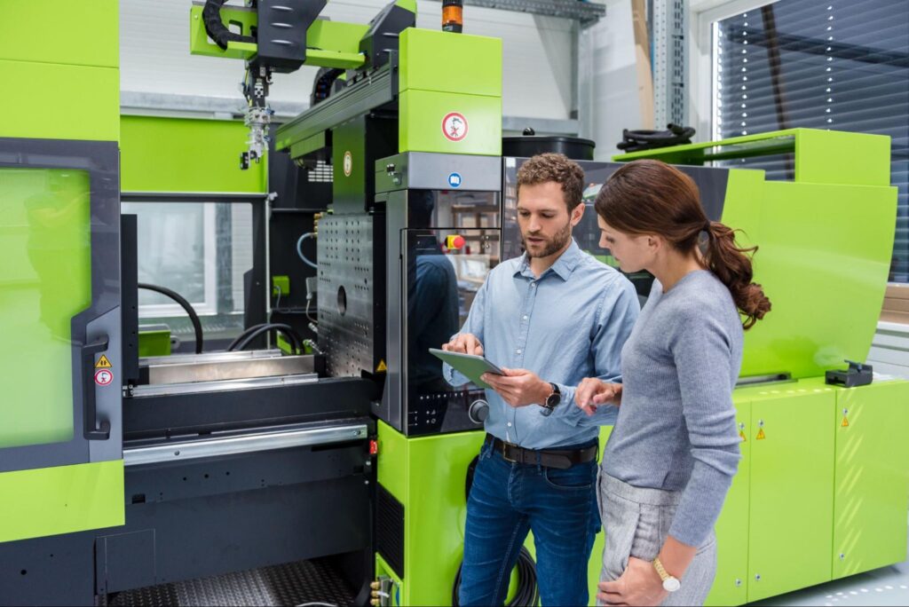 Professionals collaborating on machinery inspection and operation in a modern facility.