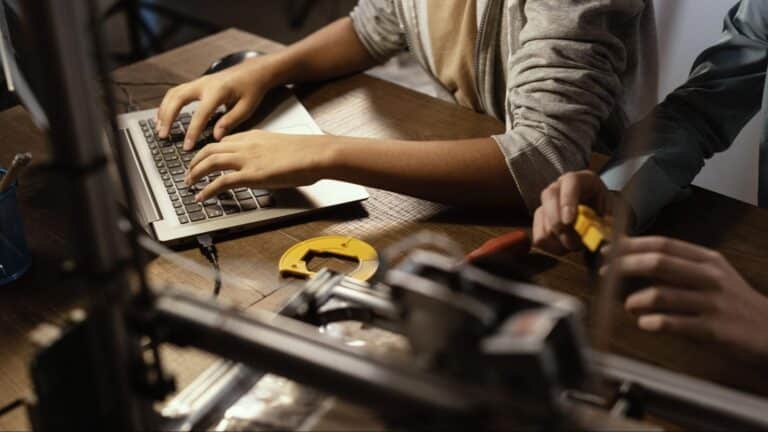 Hands working on a laptop, blending technology and creativity in a collaborative environment.