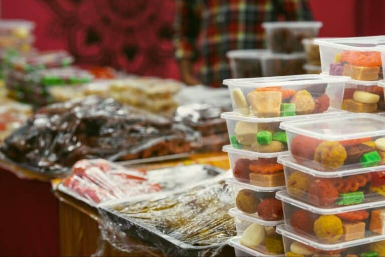 Vibrant market treats displayed in colorful containers, showcasing delicious local snacks.