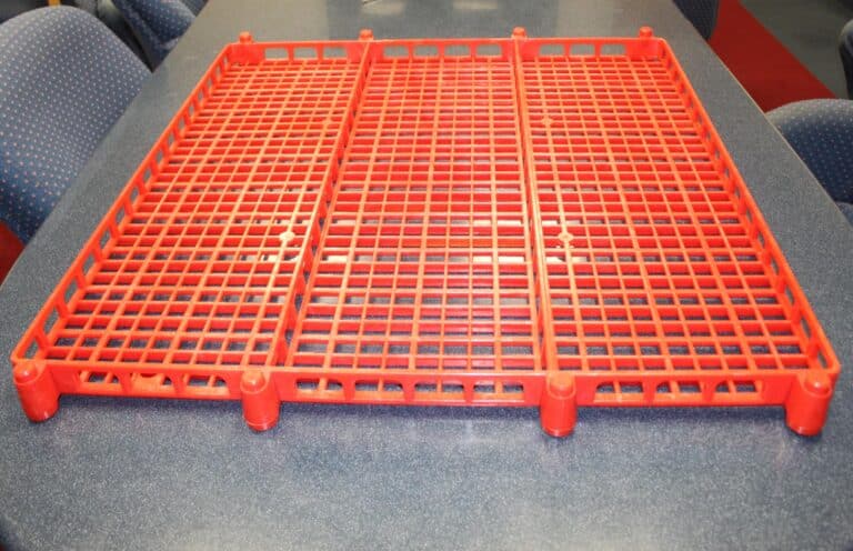Red plastic rack on a table, ideal for storage and organization solutions.